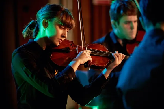 Violinist on stage in atmospheric green light