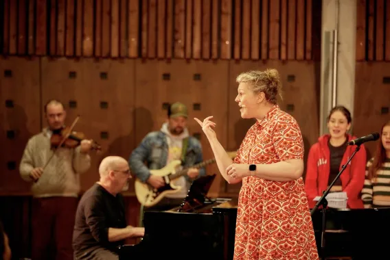 Kathleen Turner conducting choir members