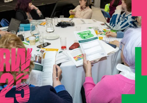 Poster for Research Week showing a group of people around a table reading documents