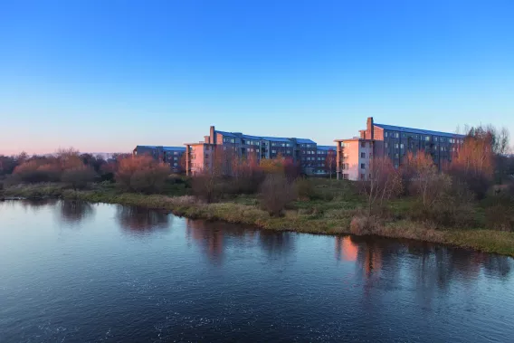 Image shows village on campus across the river