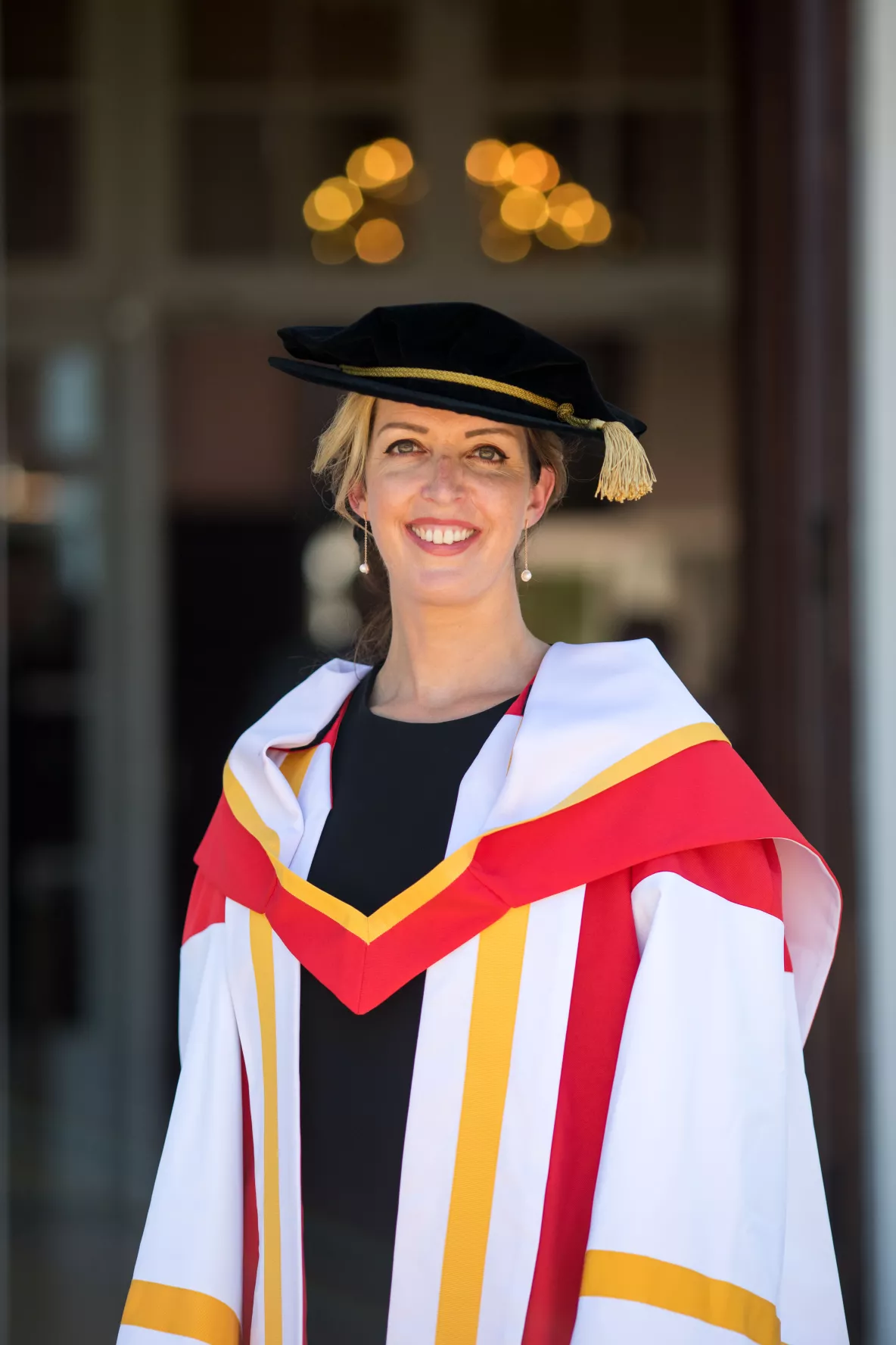 A photo of Vicky Phelan in Honorary Doctorate PhD cap and gown outside UL's Plassey House