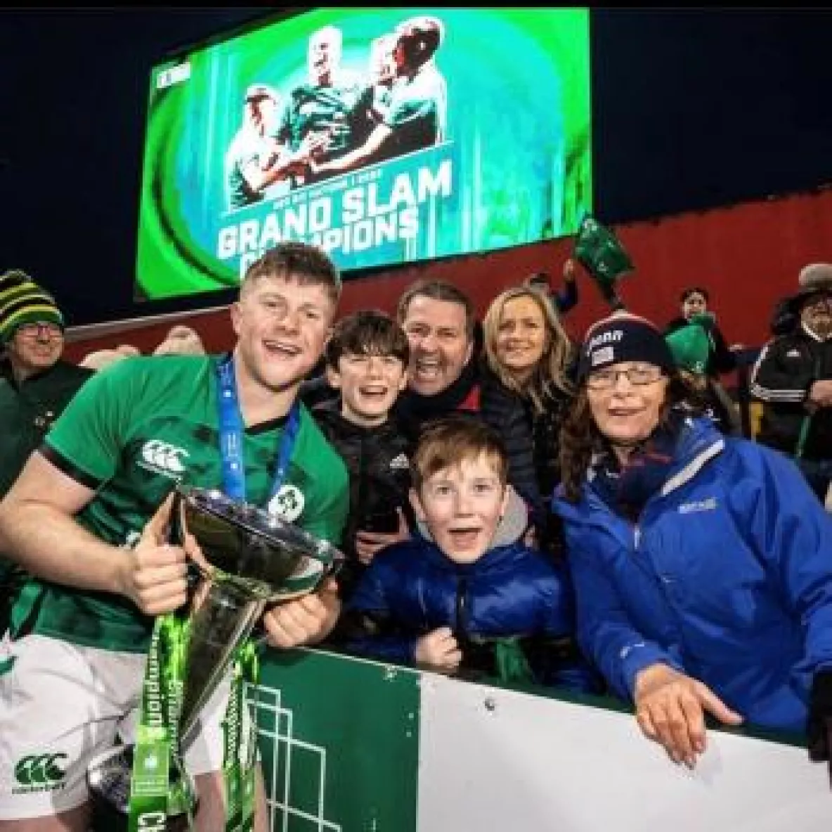 Patrick Campbell holding a trophy with his family