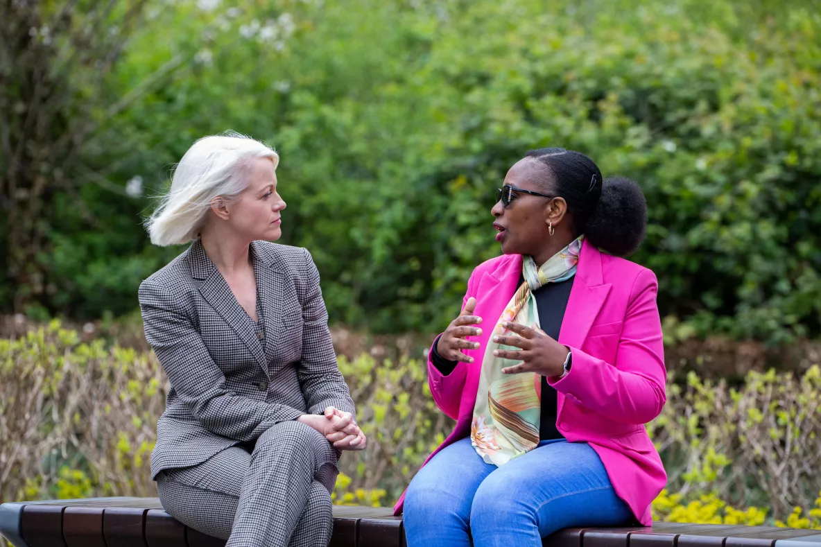 Two women sitting on a bench outside on the UL campus 