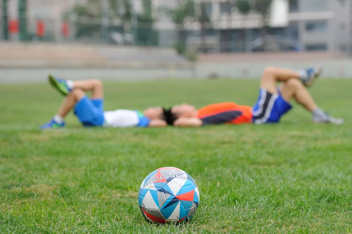 two boys on grass and soccer ball