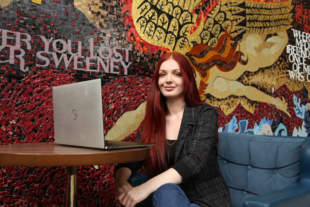 A picture of UL student Róisín Mitchell, sitting at her laptop