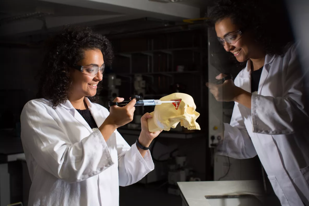 Student syringing into a skull figure