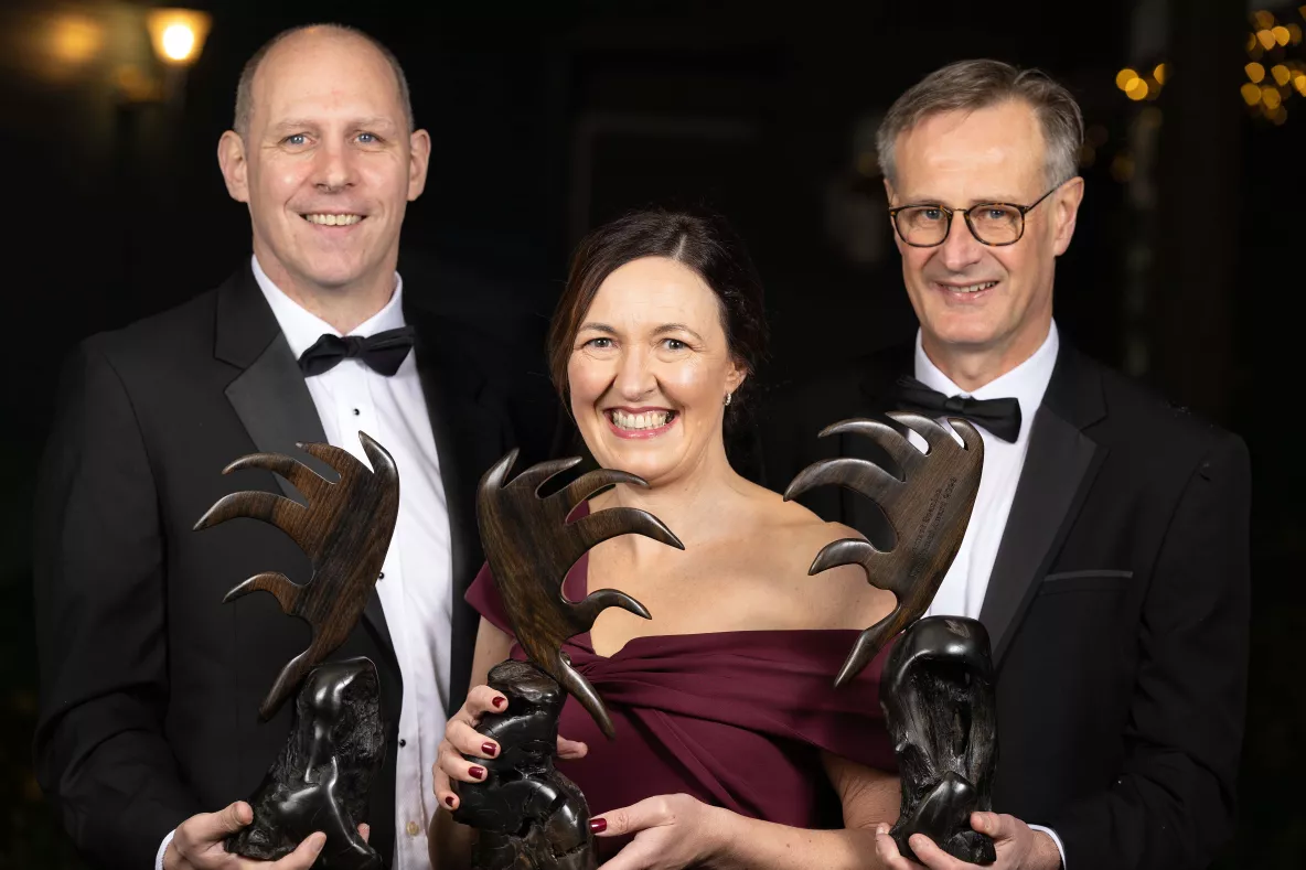 A picture of three alumni award winners with their trophies