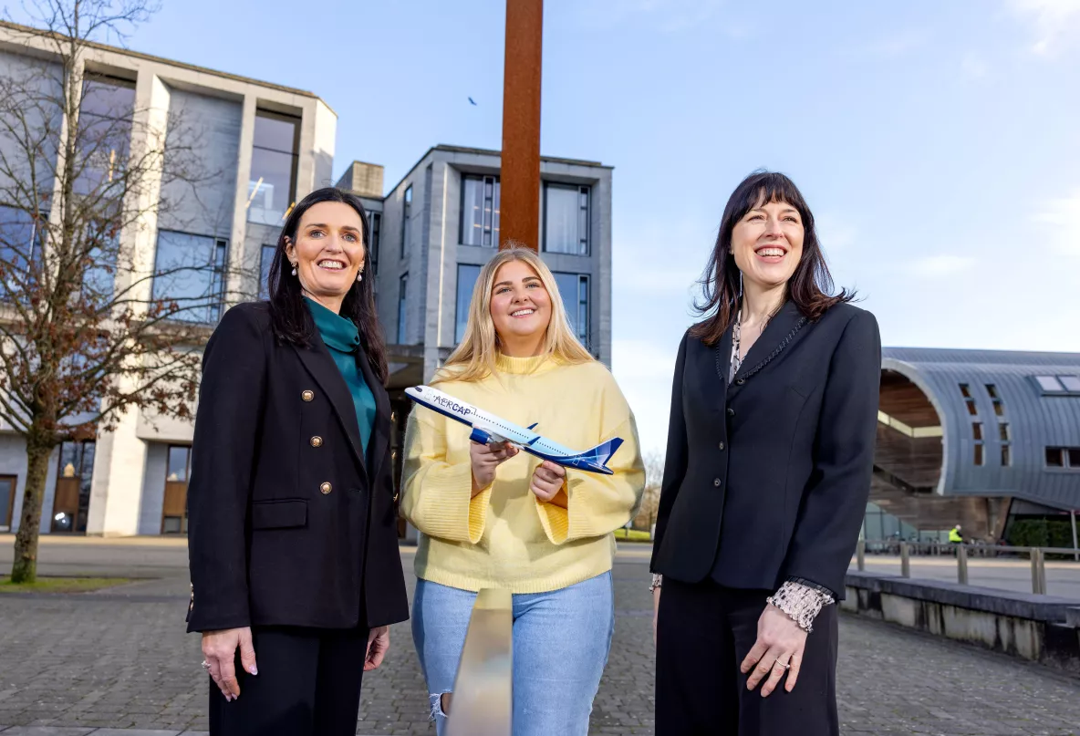 A picture of three people on the UL campus - one of them is holding a small toy plane