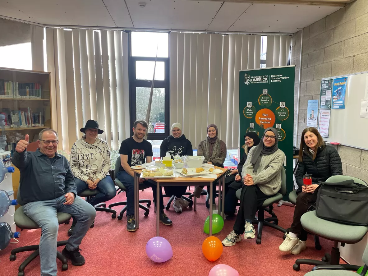 7 PhD writers gathered around a table while celebrating PhD writers week