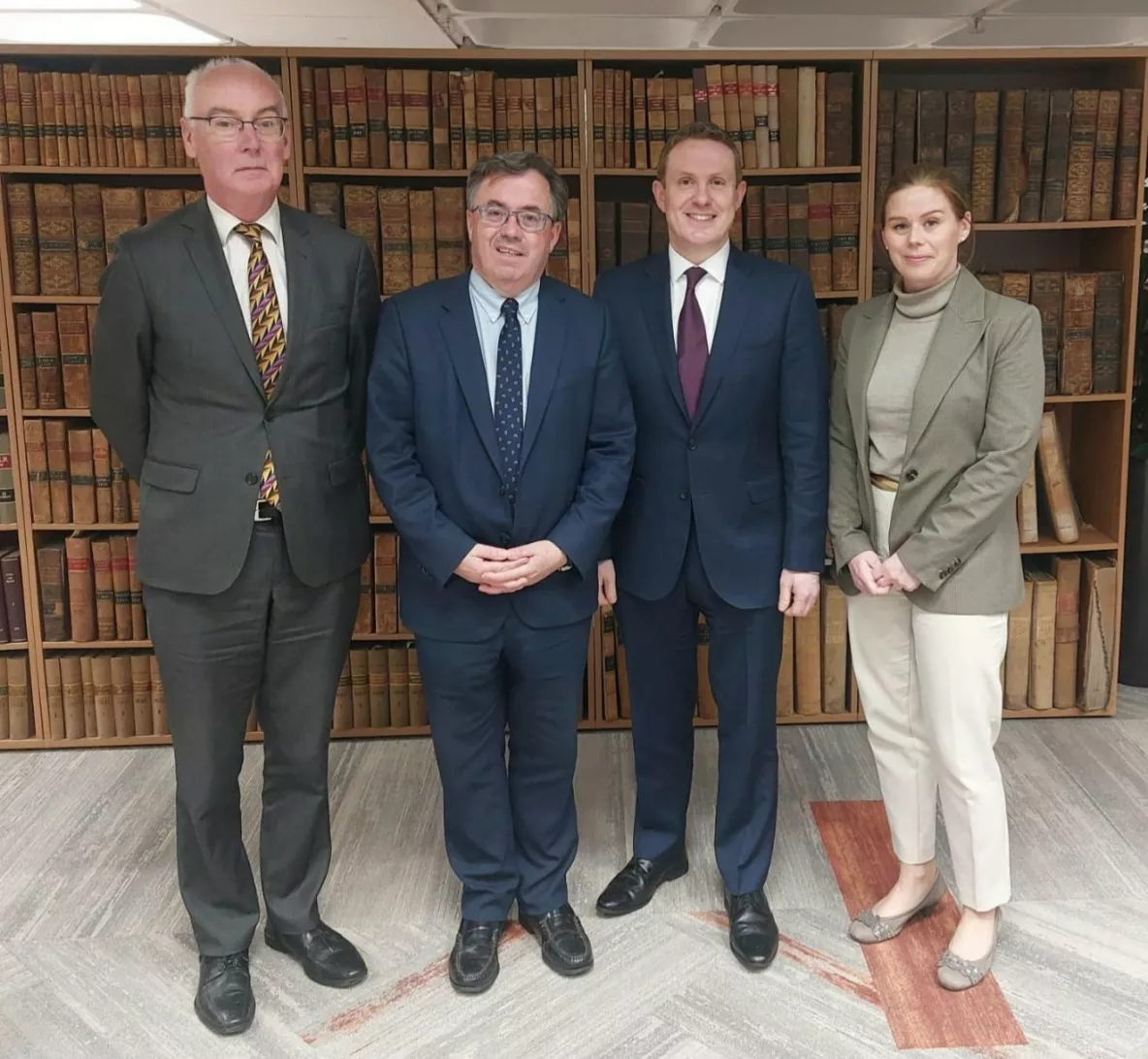 Professor Paul McCutcheon, Mr Justice Gerard Hogan, Dr James Meighenand Dr Laura Cahillane standing in front of the School of Law bookshelves