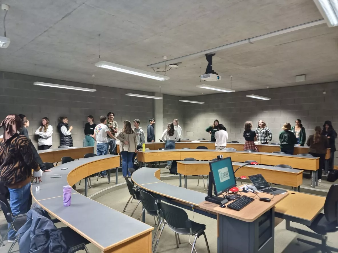 Pairs of students around a room engaging in a speed-friending exercise.