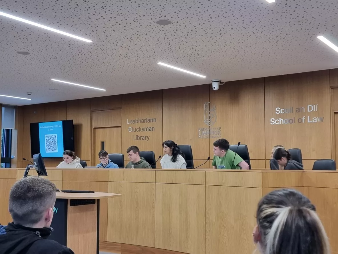 A group of students seated at the UL moot court room participating in a debate