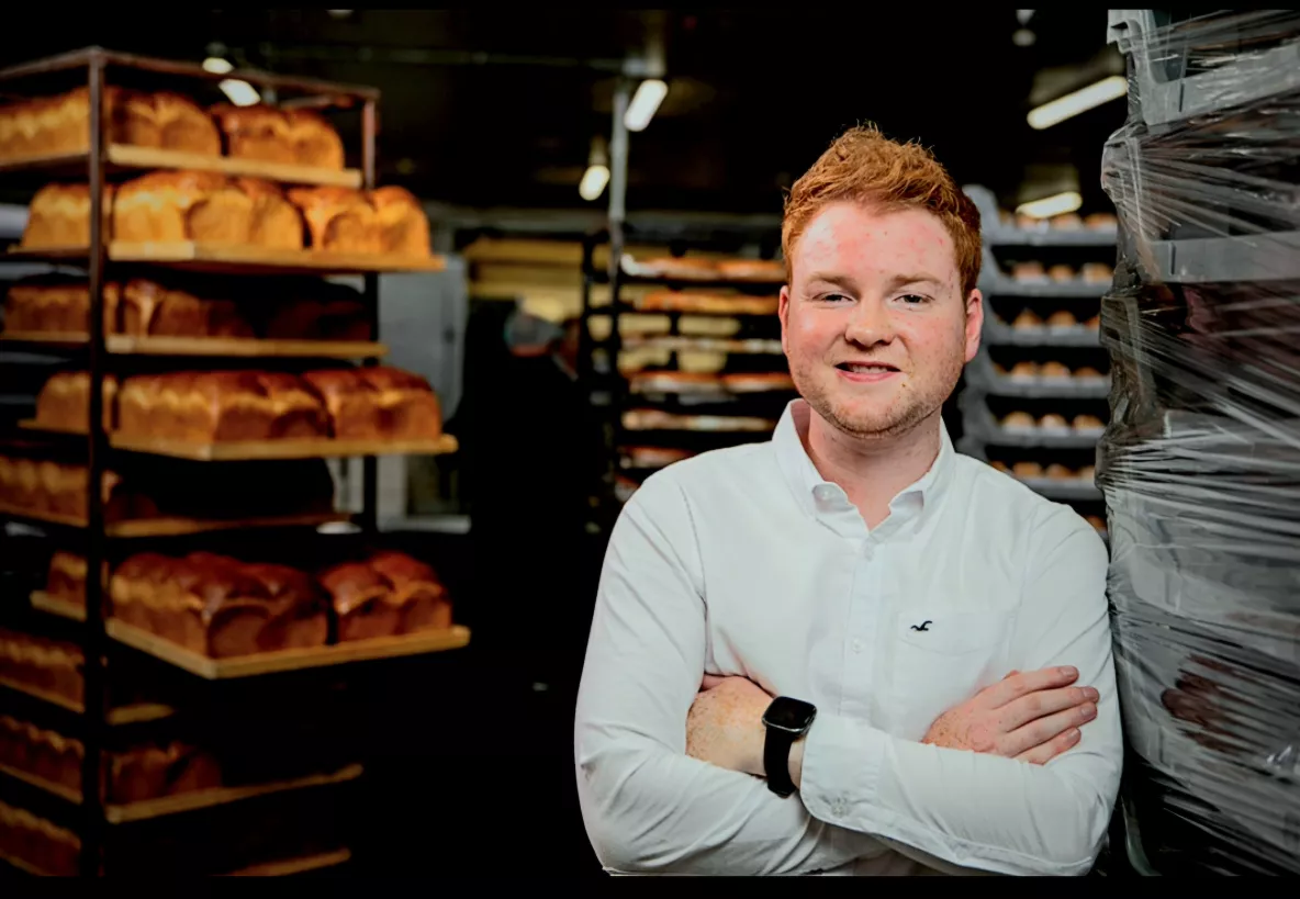 A photograph of Patrick Twomey, UL alumnus and Managing Director of Twomey's Bakery Ltd., with bakery products in the background.