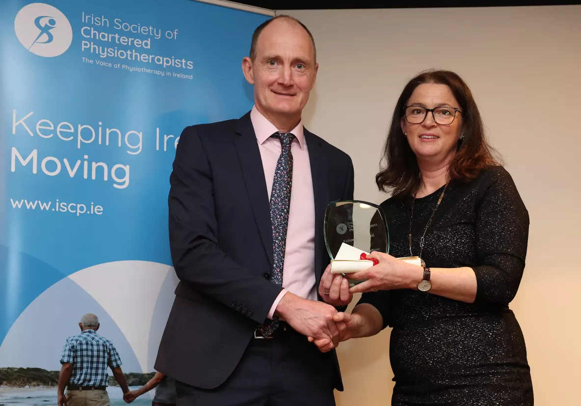 Man being presented with an award by a woman