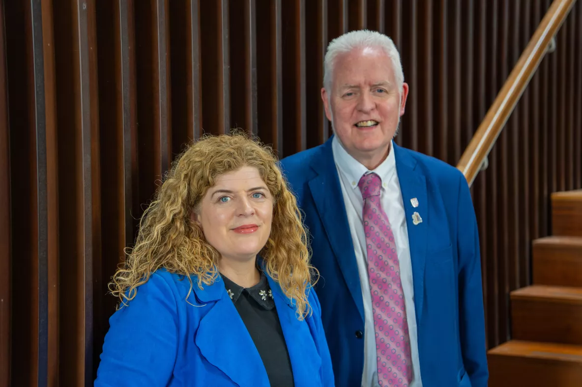 Photo of a female and male professor standing together 