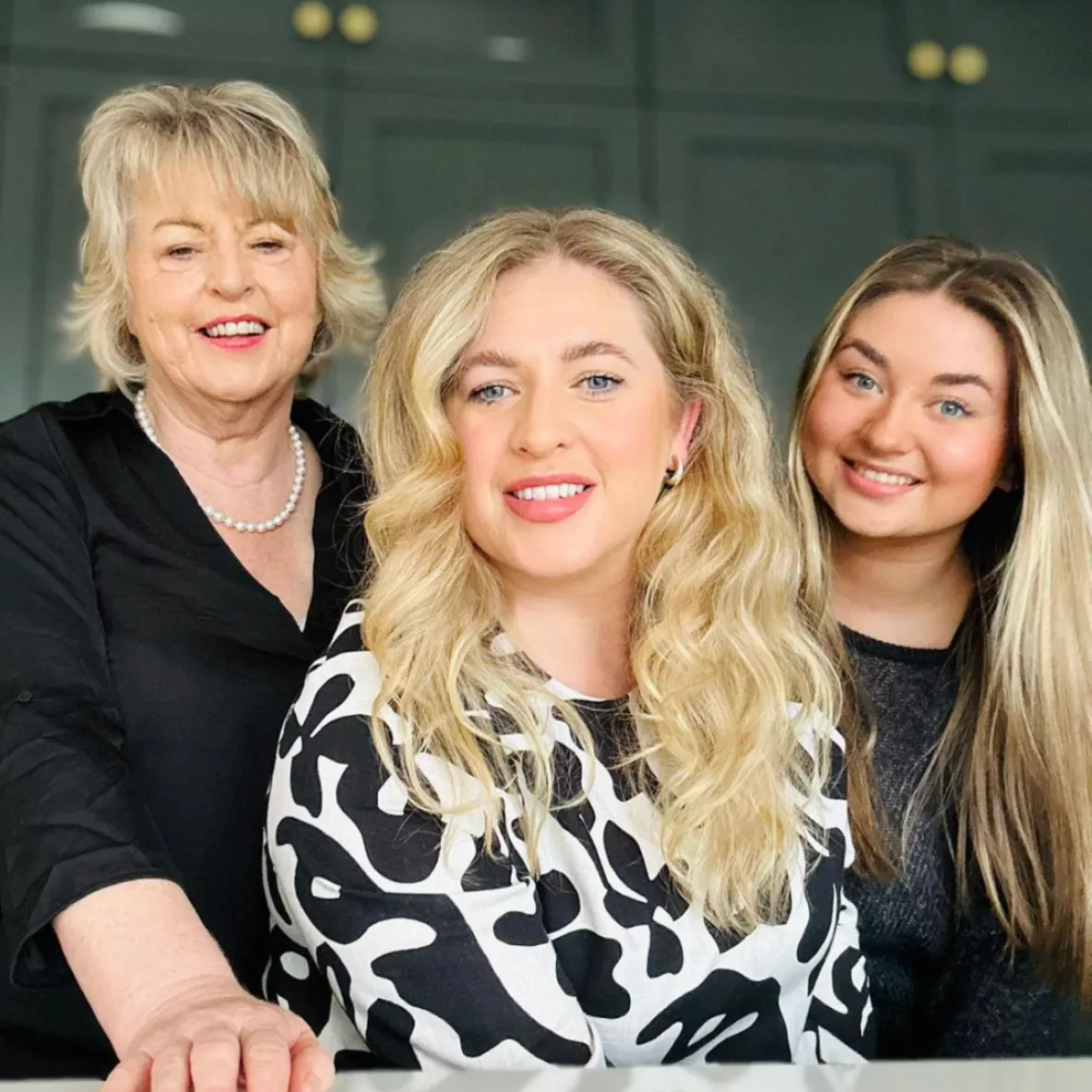 Indoor shot of three women smiling, mother, daughter and granddaughter.