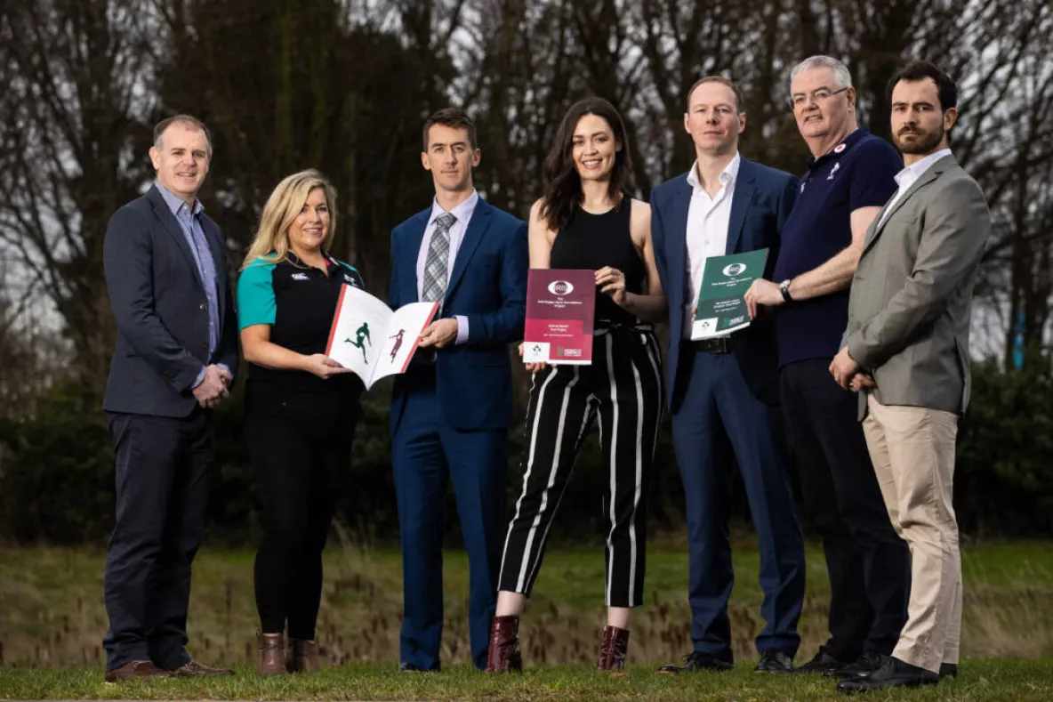 Seven people pictured holding a number of printed reports into the IRIS/IRFU rugby surveillance programme