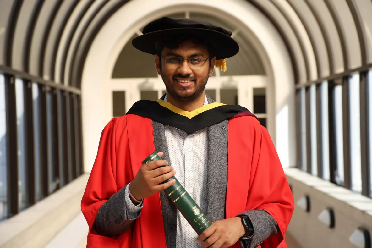 A picture of Dr Bikash Guha from Athenry in Co. Galway became the first apprentice graduate of the Professional Doctorate in Engineering (PDEng) programme at UL. He is wearing conferring robes and holding a parchment in a tunnel at UL