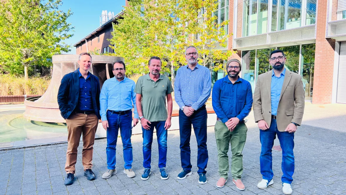 Six men standing outside the Bernal Institute in a group posing for a photo