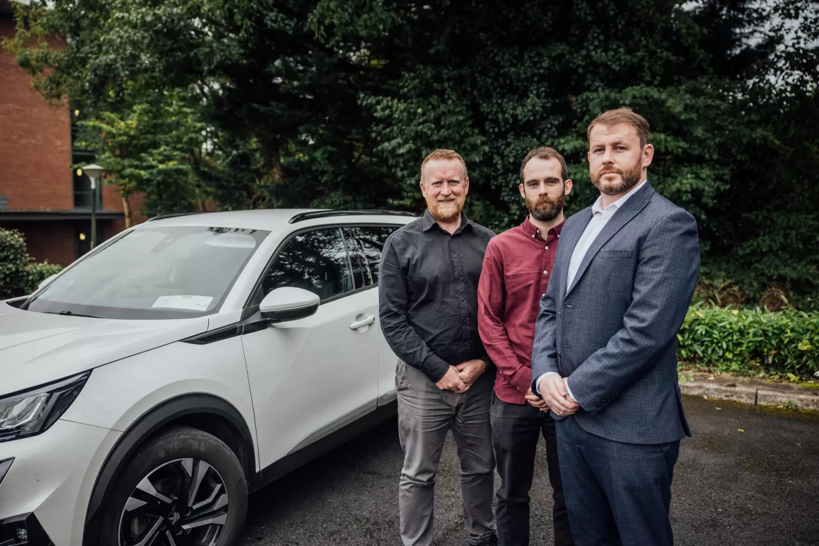 Three men pictured next to a white car on the UL campus - they are Lero-UL researchers Professor Finbarr Murphy, Kevin McDonnell and Dr Barry Sheehan 