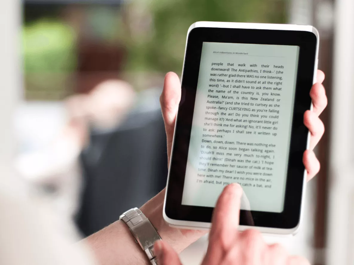 hands holding an e-reader with text on it