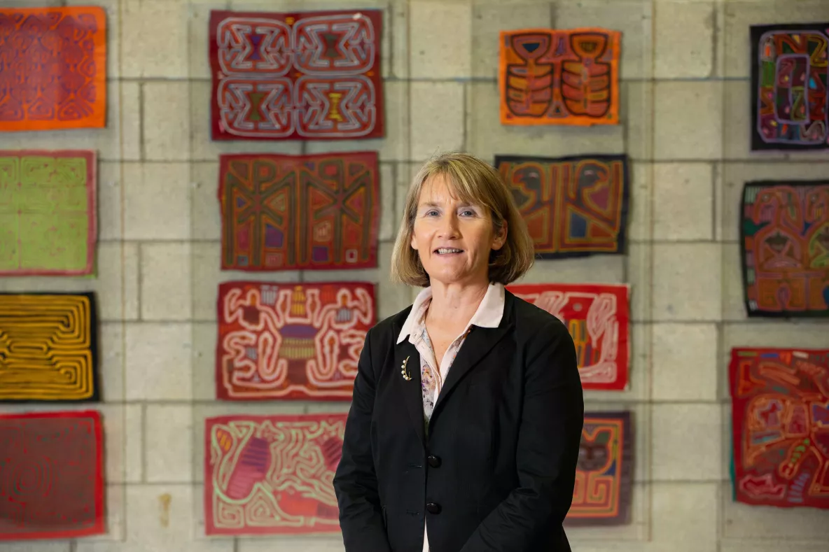 Photo of woman standing in front of multi-coloured fabric panels