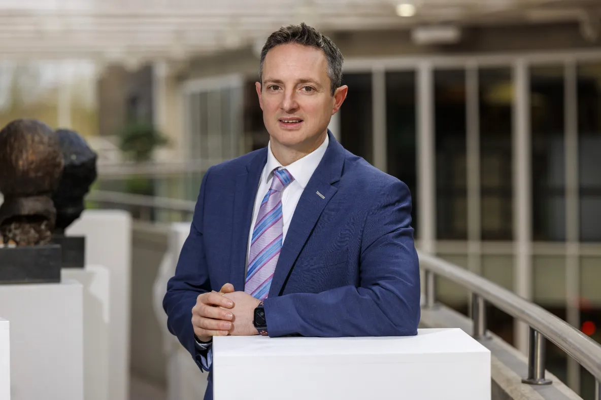 A picture of Professor Kevin M Ryan standing at a white column in UL