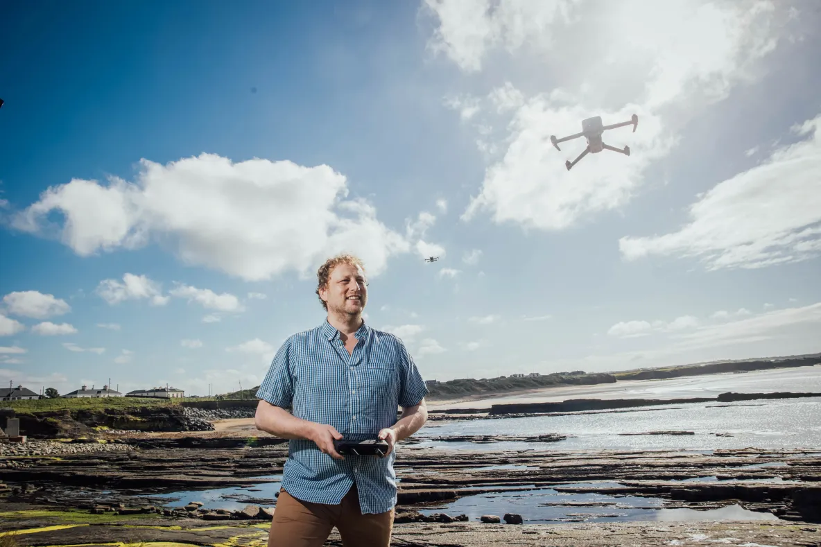 A picture of Professor Gerard Dooly operating a drone on a beach