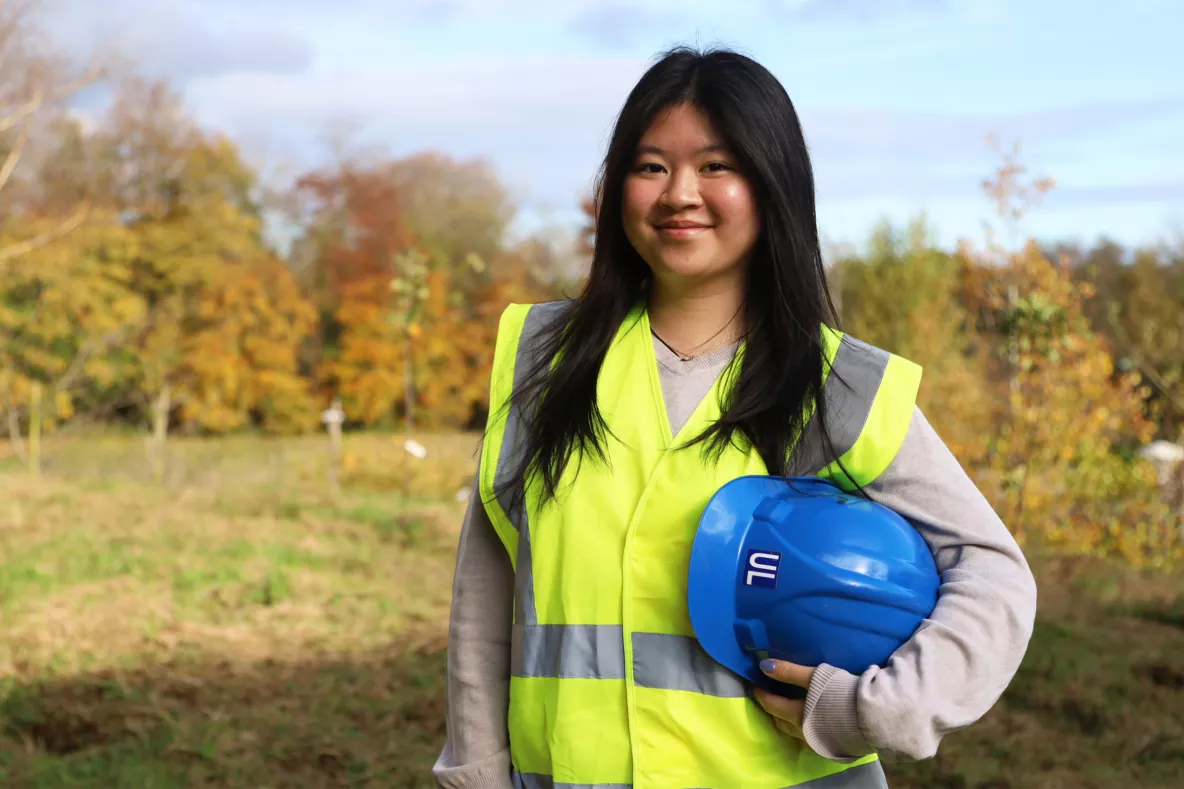 A picture of Madissen Cayla Ashlee Pangestu wearing a high vis vest and holding a blue hard hat