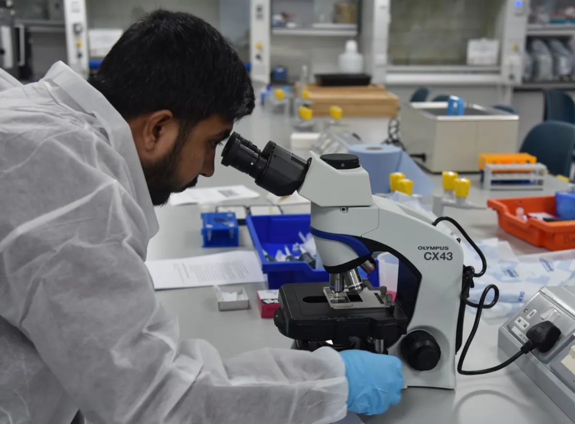 student looking into microscope