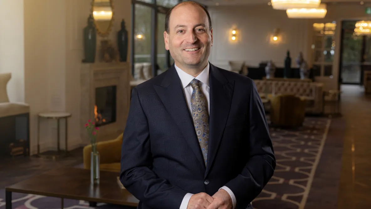 A photo of a man in formal dress standing in an ornately decorated room