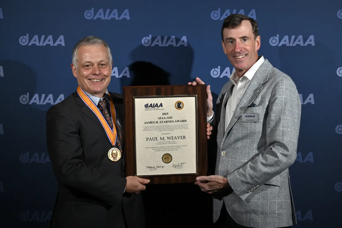 Man being presented with certificate by another man in award ceremony setting