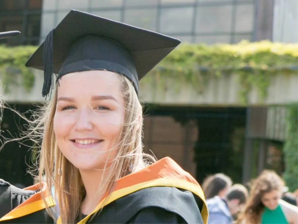 Smiling woman in graduation cap and gown