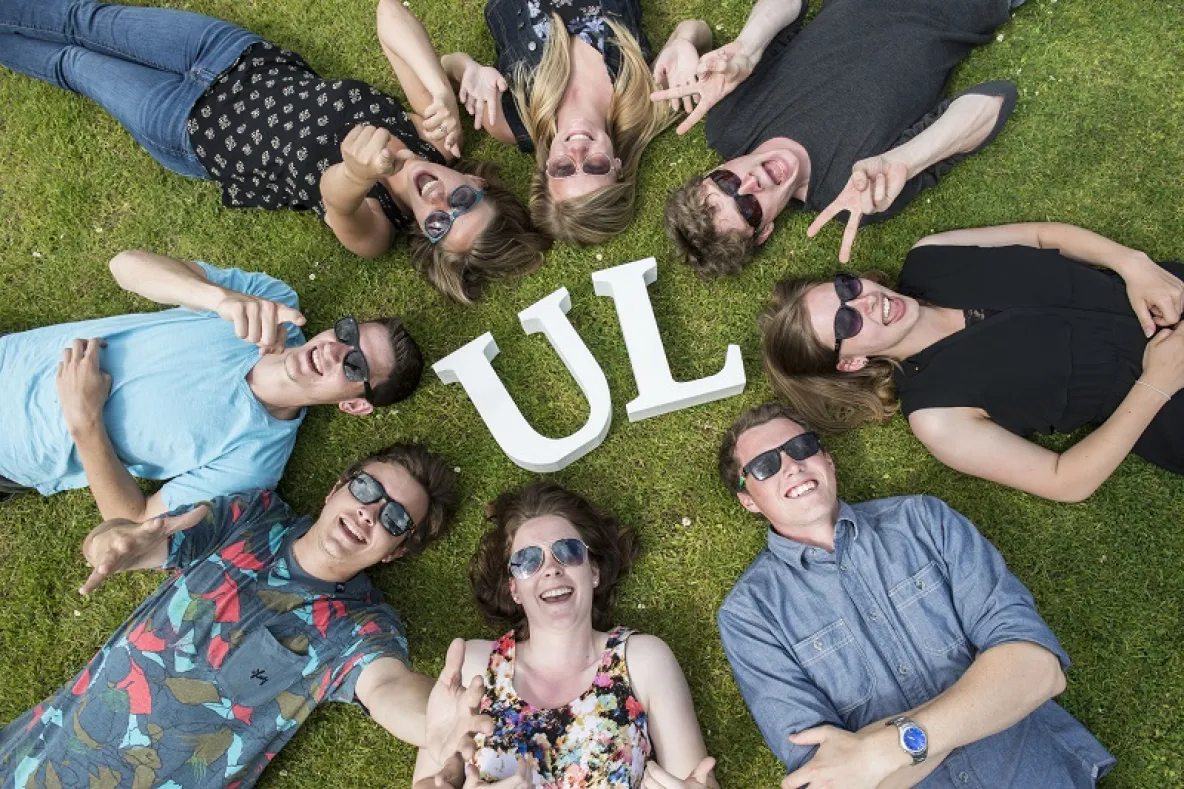 international students enjoying the sun with UL sign