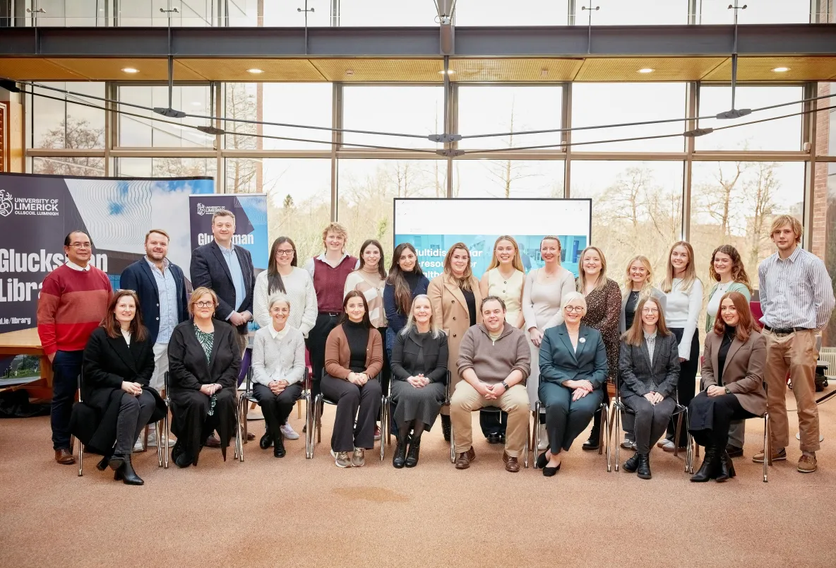 Large group of people posing for photo in an indoor setting