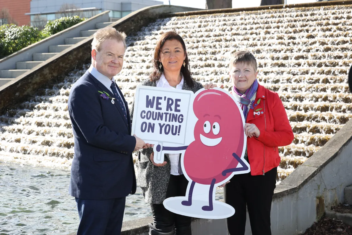 A picture of three people holding a cut out sign that says 'we are counting on you'