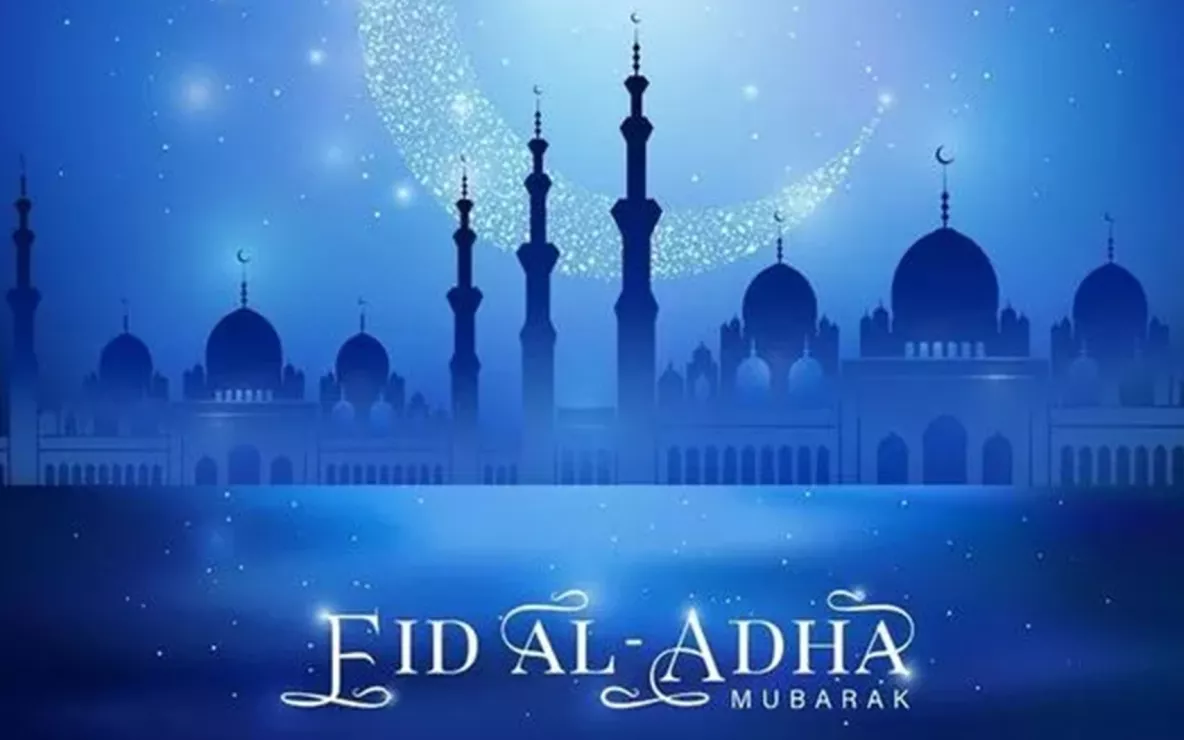 Image exclaims Eid Al-Adha Mubarak with buildings and sky in the background in blue and gold