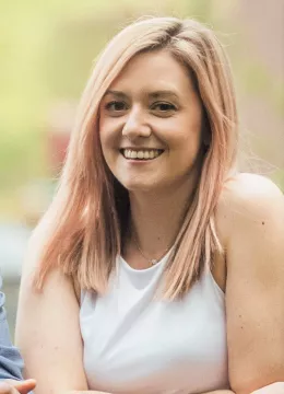 A blonde woman with a white top on