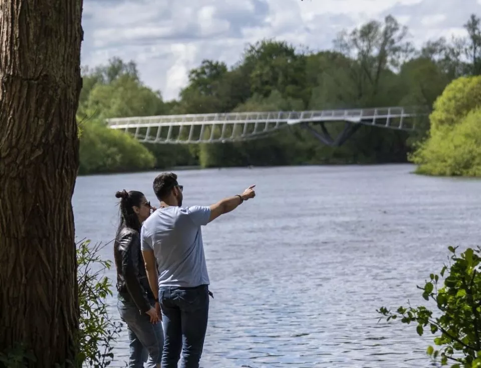 2 people beside the river Shannon looking at the living bridge