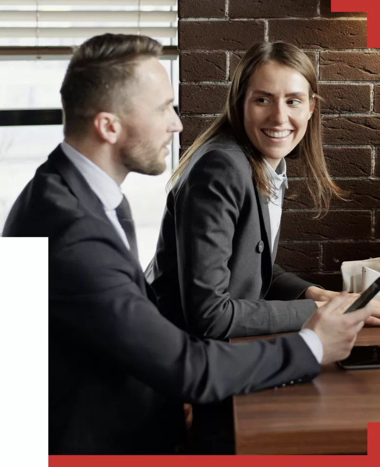 Business man and Business Woman wearing suits chatting and smiling