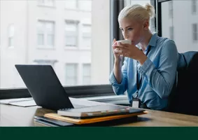 student drinking coffee at the laptop