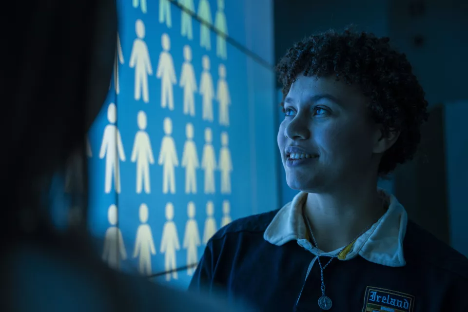 Student standing beside projector screen