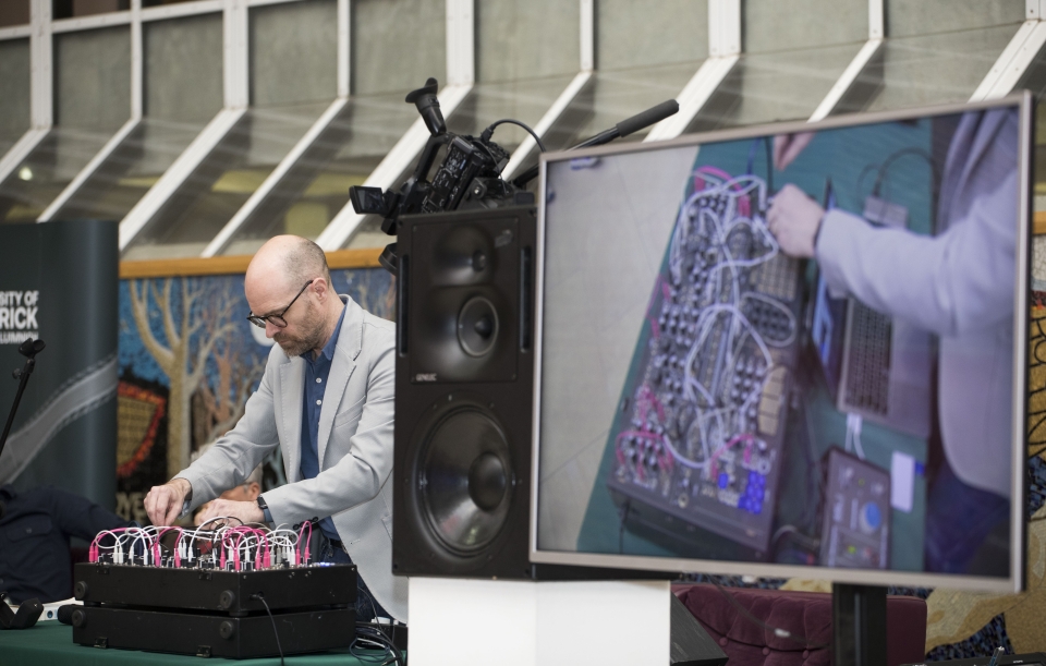 Man playing electronic music using a computer board, on right is close up image of the board
