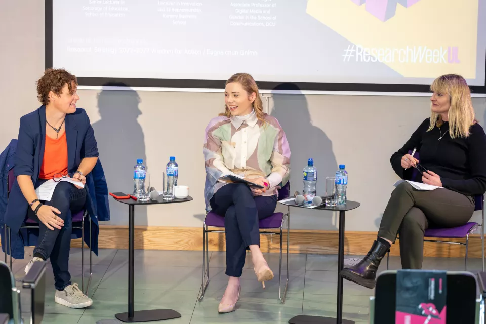 Three women sitting on a stage