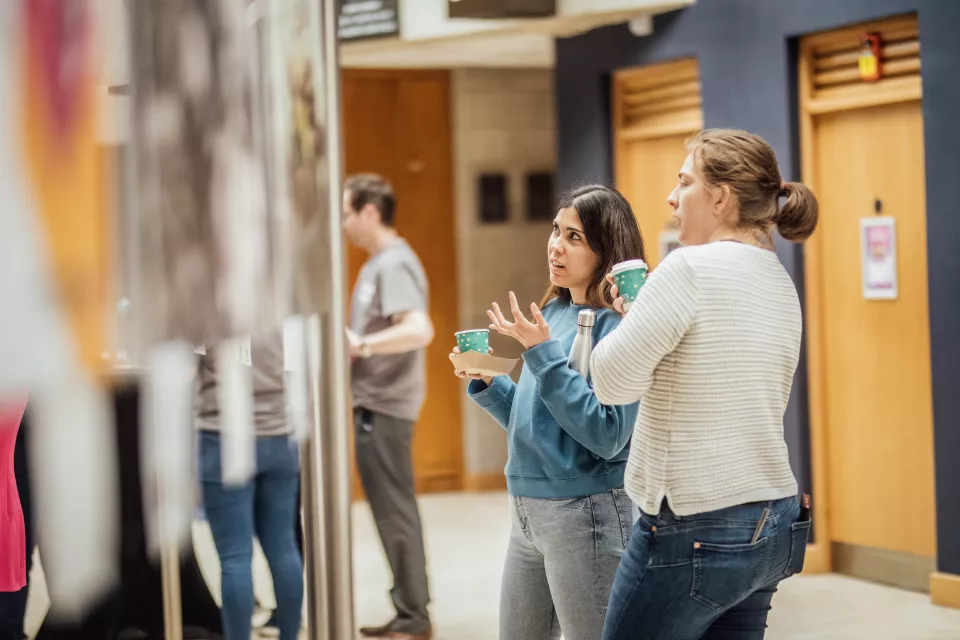 Two women viewing posters