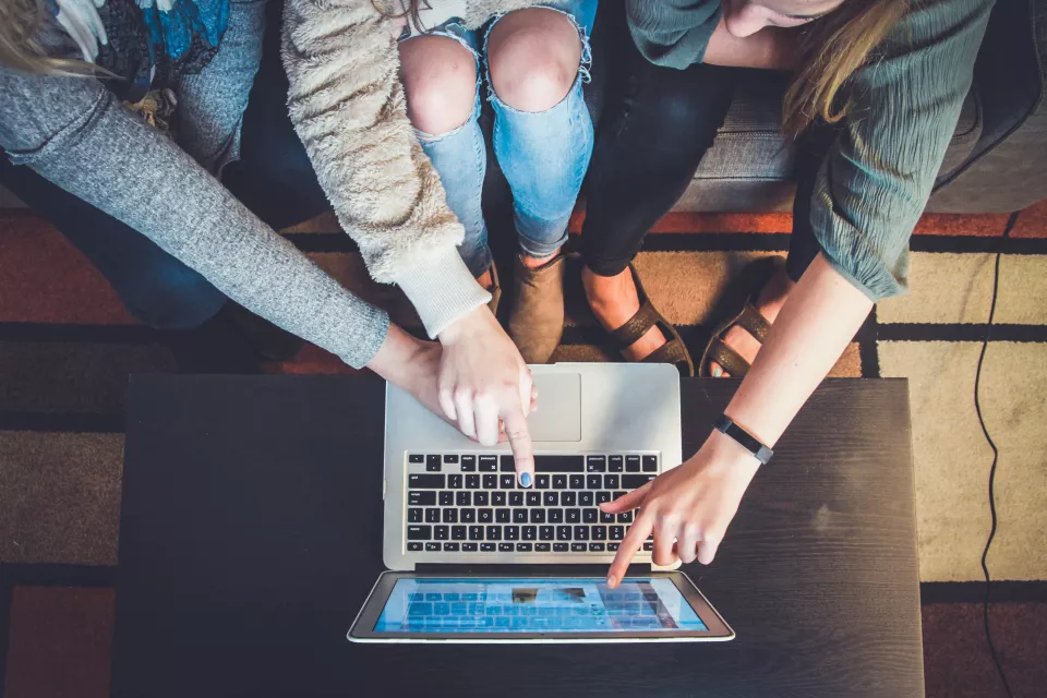 Students point at laptop 